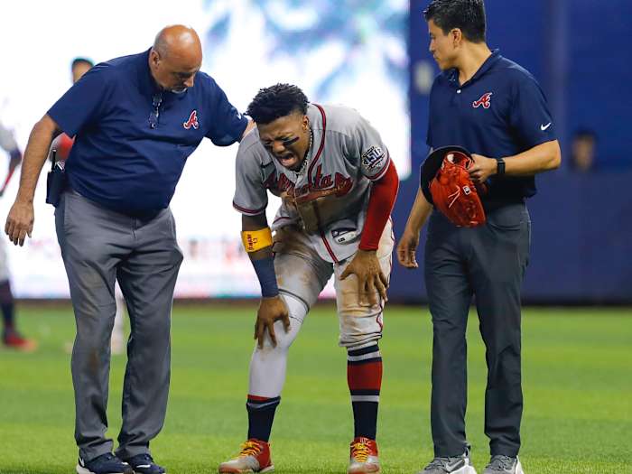 Atlanta Braves right fielder Ronald Acuna Jr. (13) reacts as he gets check on by training staff after an apparent leg injury during the fifth inning against the Miami Marlins at loanDepot Park.